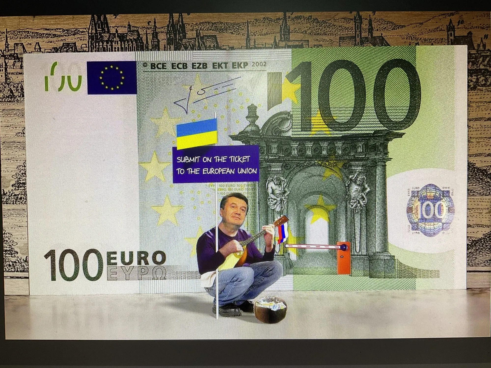 Cartoon “Spare a Ticket to Europe” by Oleksandr Zinovyev: A man begging under the arch of a giant 100 euro banknote with a sign about a ticket to the EU.
