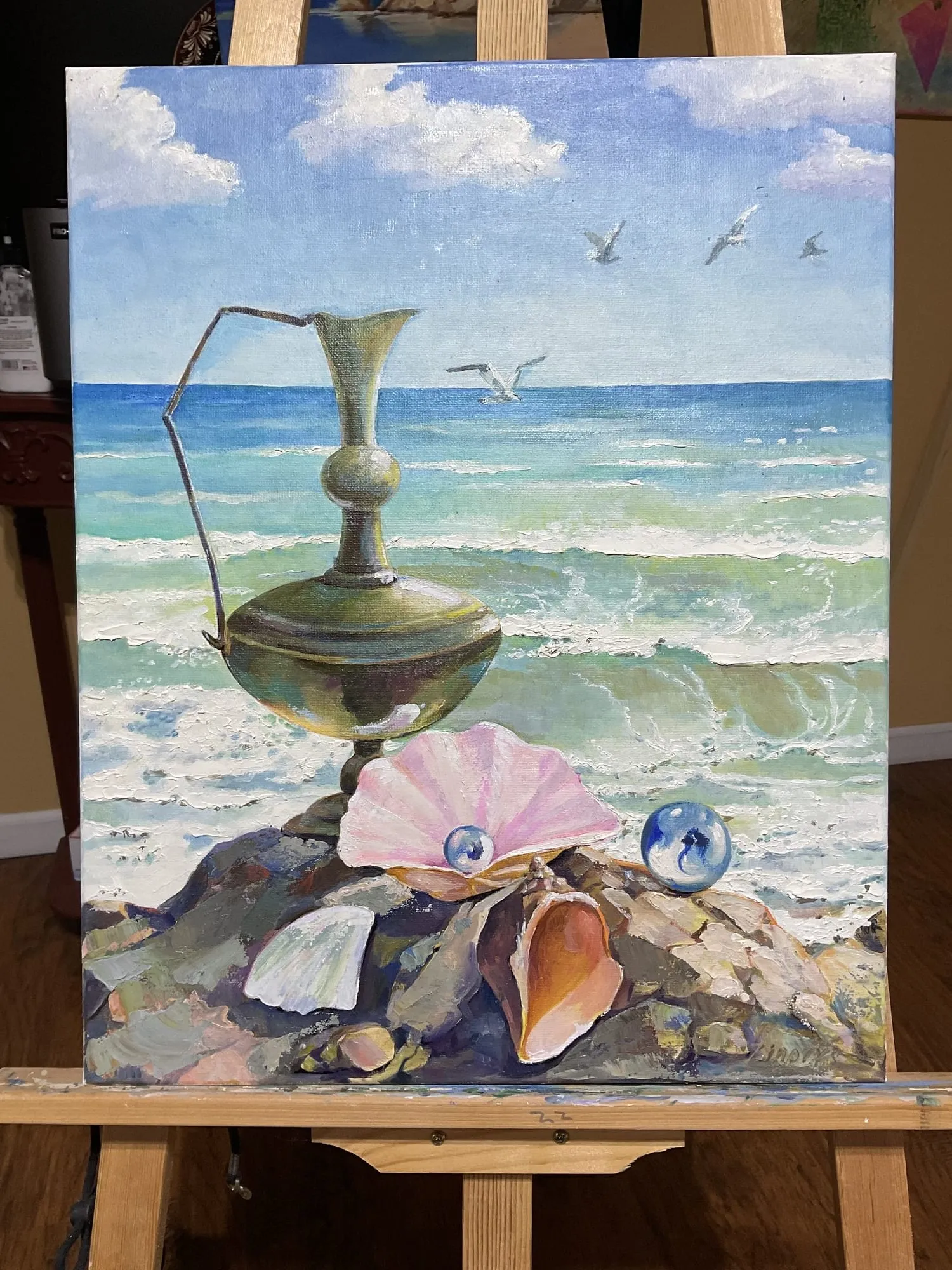 Painting “Snails and a Vase” by Oleksandr Zinovyev: A brass jug and seashells on rocks by the surf, with gulls overhead; photographed on the easel.